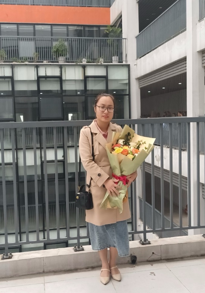 A person holding flowers in front of a building

Description automatically generated